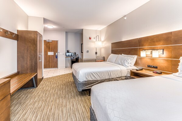 A hotel room with two beds, a wooden wardrobe, a desk, a lamp, and a small table with a phone and a clock. - Holiday Inn Express & Suites Rantoul by IHG (Rantoul)