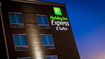A Holiday Inn Express & Suites building with a modern design, featuring multiple windows and a prominent logo.