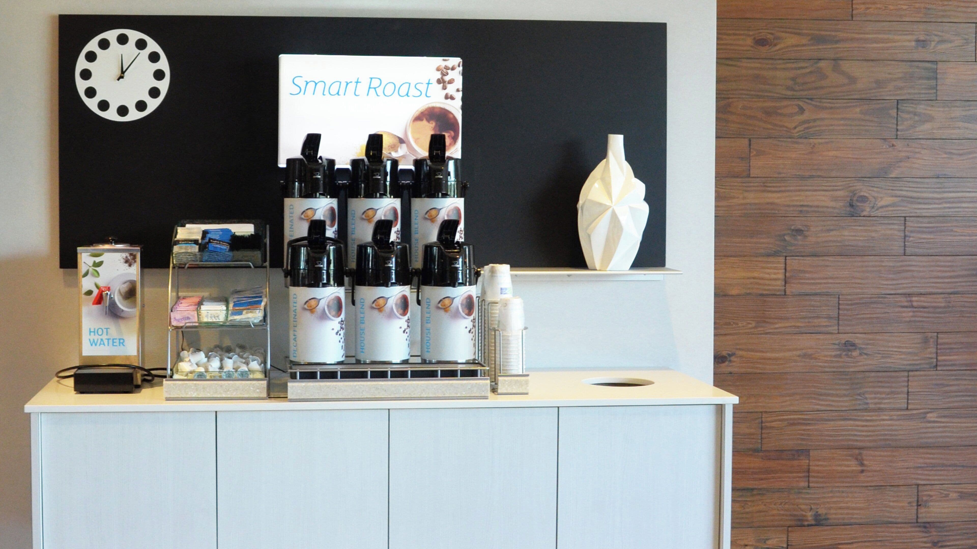 A coffee station with a clock, a sign for 'Smart Roast', and various coffee products.