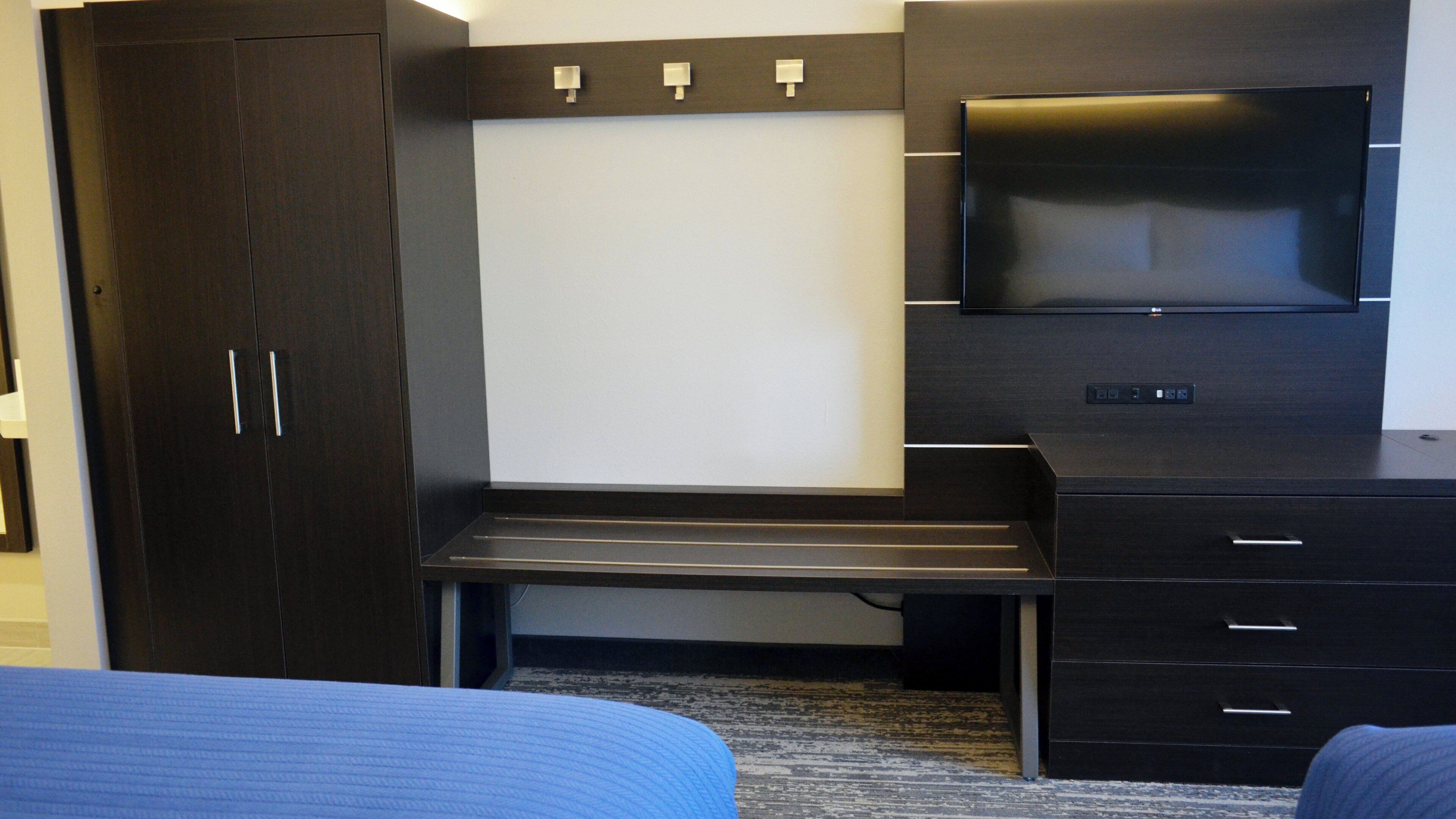 A hotel room with a bed, a desk, a TV, and a wardrobe.