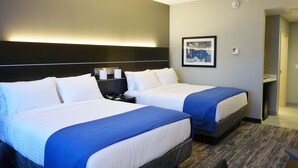 Habitación de hotel con dos camas, una mesita de noche, un cuadro en la pared y piso alfombrado.
