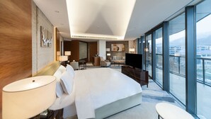 Camera d'albergo moderna con un letto grande, una TV, una scrivania e vista sulla città.