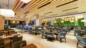 A spacious hotel lobby with multiple seating areas, a bar, and a large green wall with plants. - Holiday Inn Nanjing Xuanwu Lake by IHG (Nanjing)
