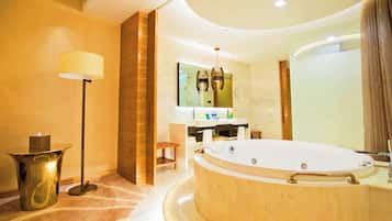 Un baño moderno con una bañera grande, un tocador con espejo y una lámpara de pie.