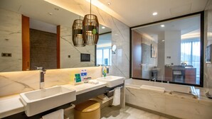 Un bagno moderno con due lavabi, uno specchio grande e una vasca da bagno.