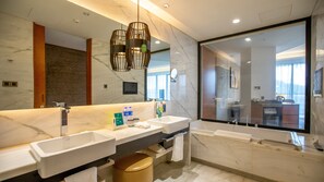 Un baño moderno con dos lavamanos, un espejo grande y una bañera.