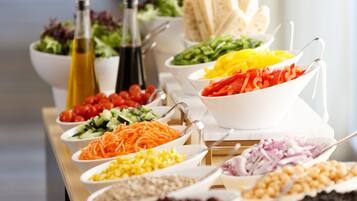 Una mesa de buffet con diversos alimentos y salsas.