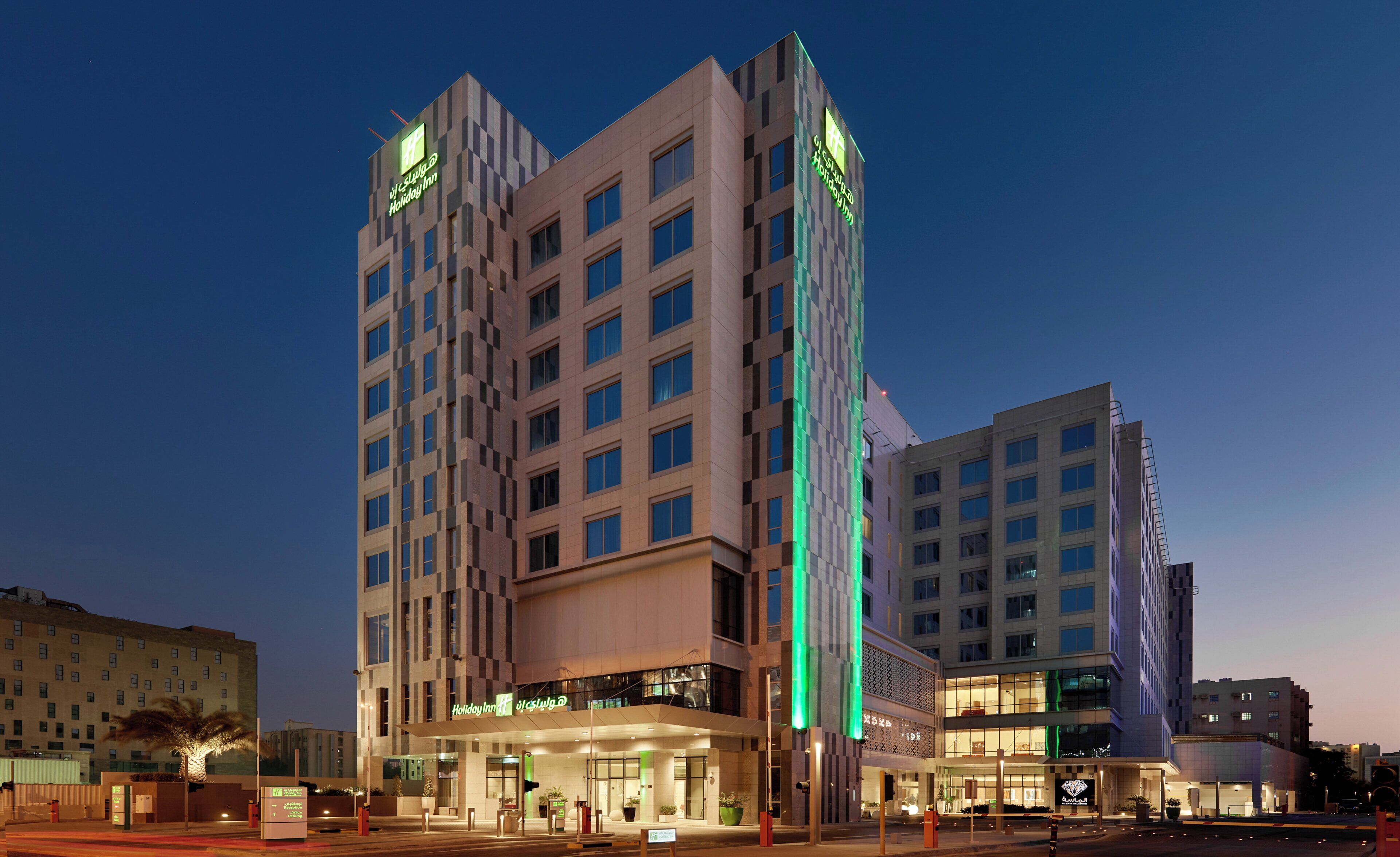 Um hotel de vários andares com design moderno, apresentando uma entrada imponente e uma fachada de vidro extensa.