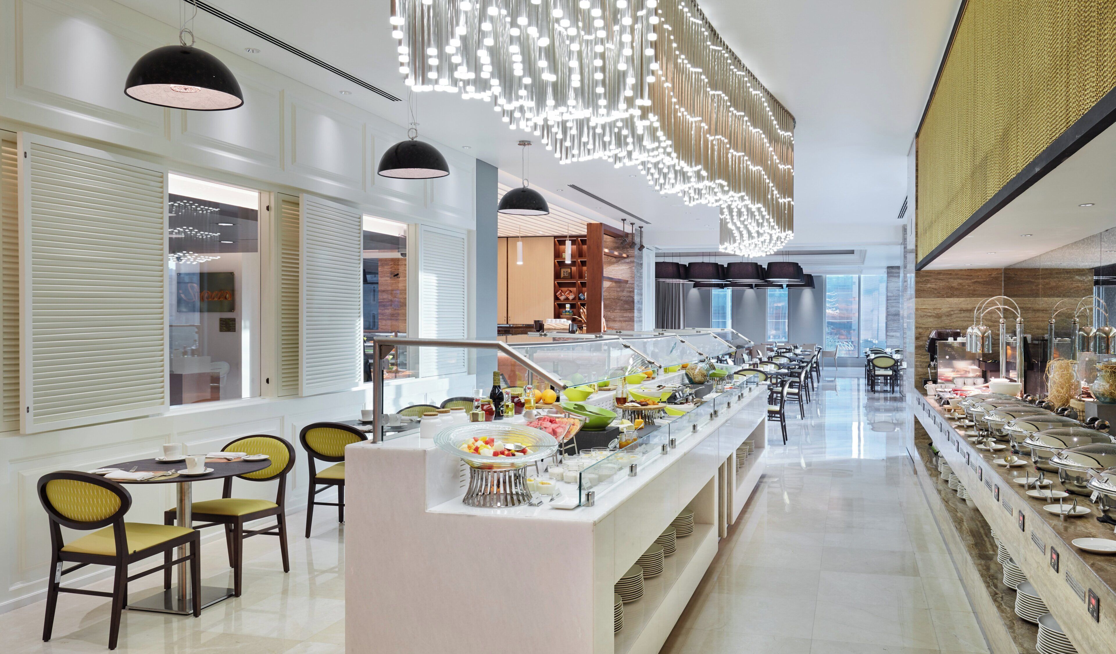 A buffet area with a variety of food items and a seating area with chairs and tables.
