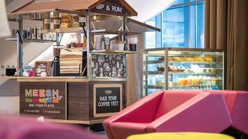 Un quiosco de café con un letrero que dice 'MEESH ME-TIME CAFE' y la pregunta '¿YA TOMÓ SU CAFÉ?' con un número de contacto.