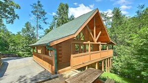Eine Holzhütte mit Balkon, überdachter Veranda und Picknicktisch.