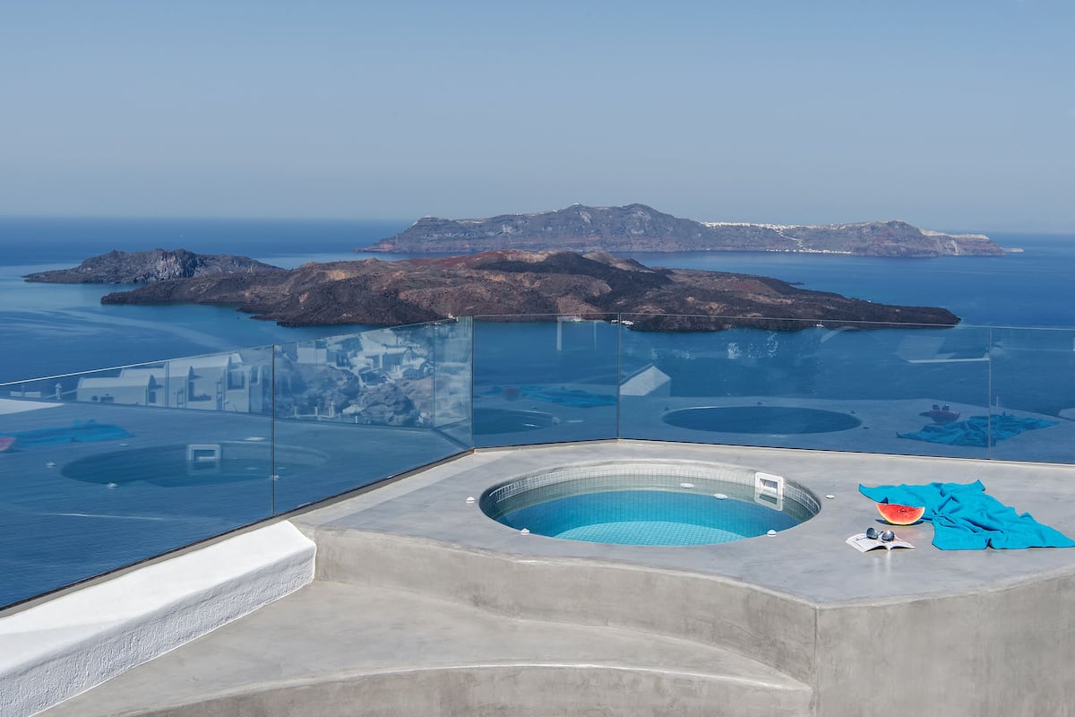 A modern infinity pool with a clear view of the sea and islands.