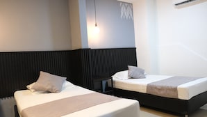 Two beds with headboards, a bedside table, a hanging light, and an air conditioning unit. - Hotel Palmas Del Estadio (Medellín)