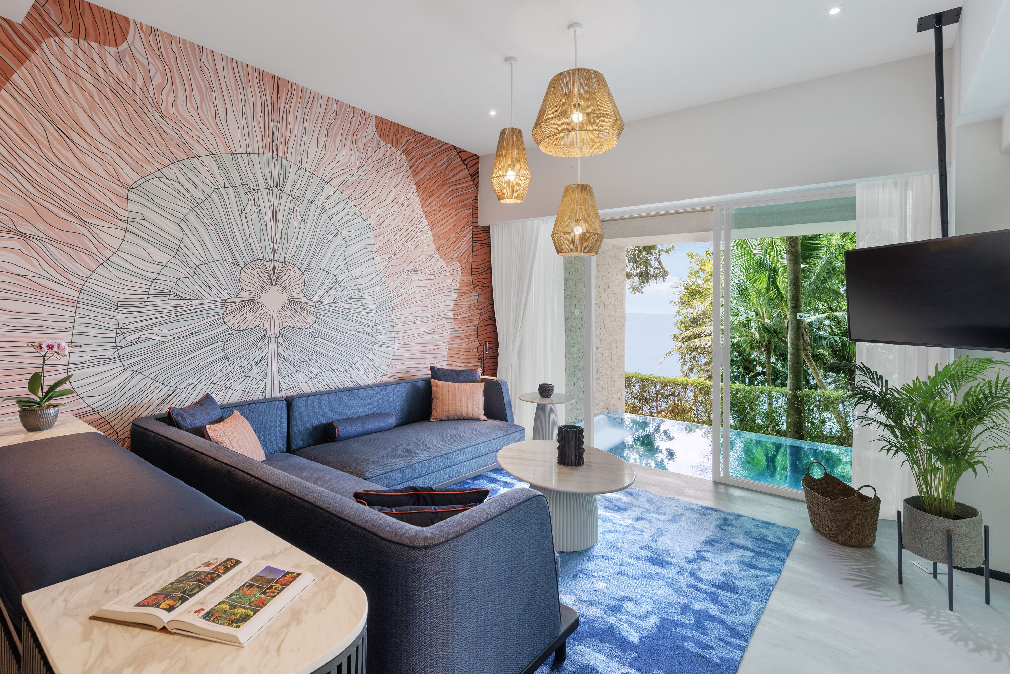 A modern living room with a large abstract wall art, a blue sofa, a coffee table, and a TV.