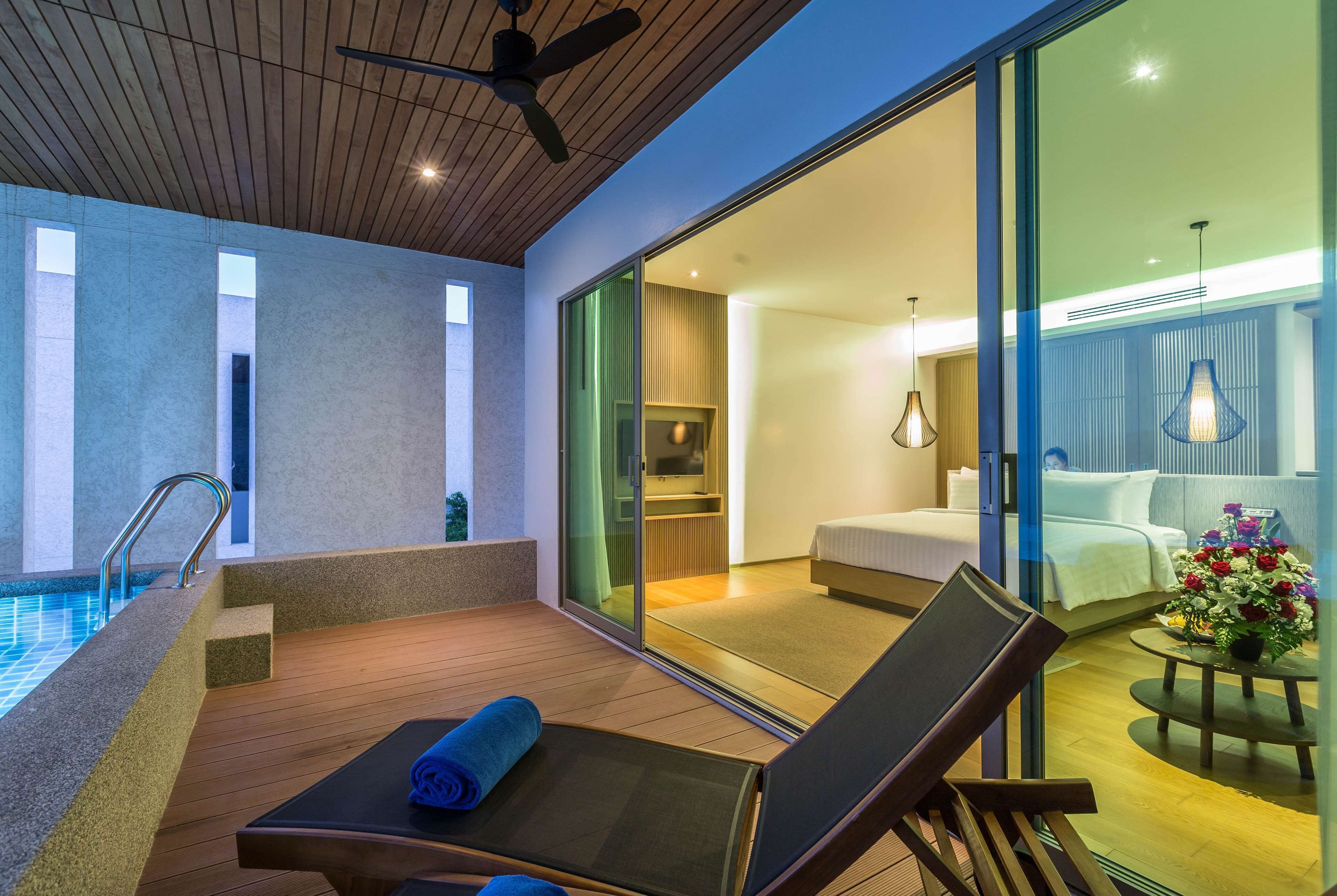 Una habitación de hotel moderna con balcón, piscina y vistas a la ciudad.
