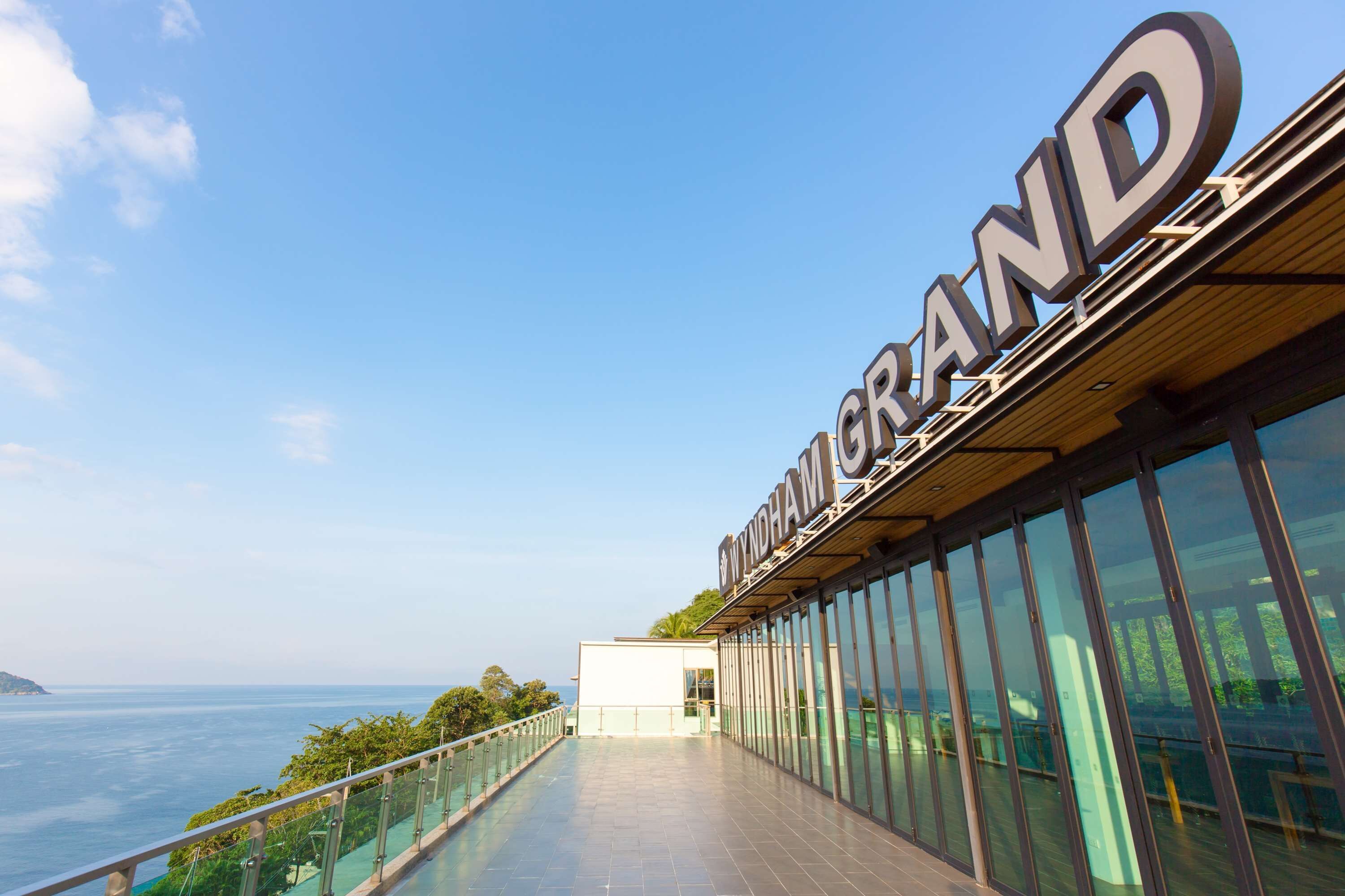 Een modern hotel met een grote glazen gevel en uitzicht op zee.