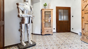 Una habitación con una estatua de un caballero, un armario de madera y suelo con diseño.