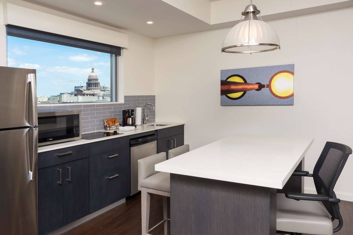 Una cocina moderna con vistas a un edificio del capitolio, un comedor con una mesa blanca y un cuadro en la pared.