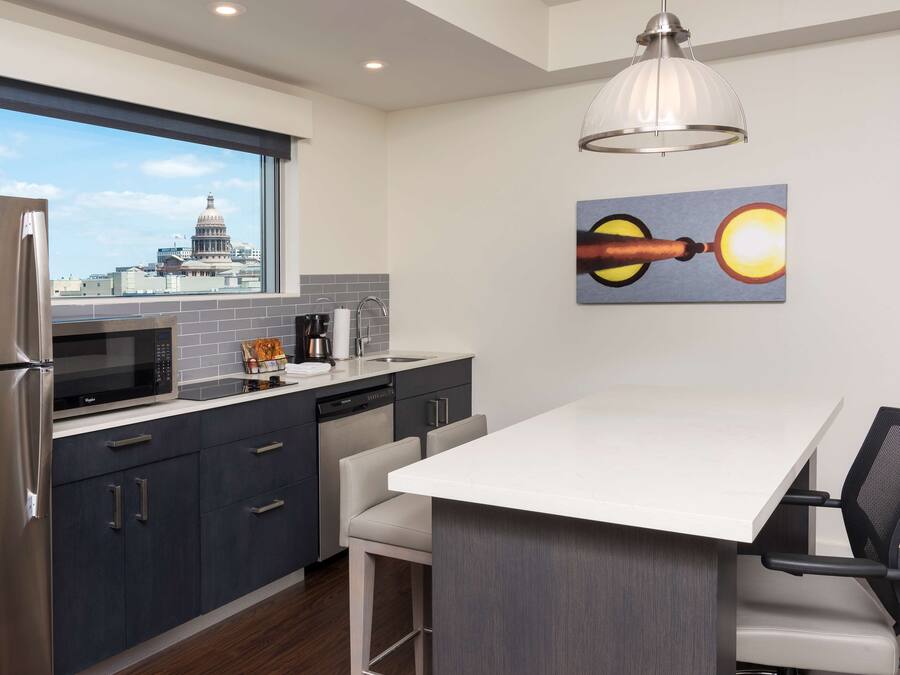 Una cocina moderna con vistas a un edificio del capitolio, un comedor con una mesa blanca y un cuadro en la pared.