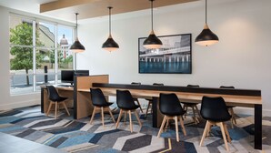 A modern meeting room with a long table, black chairs, and pendant lights. - Hyatt House Austin/Downtown (Austin)