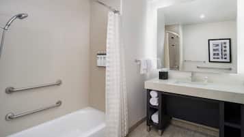 A modern bathroom with a bathtub, shower, and vanity.