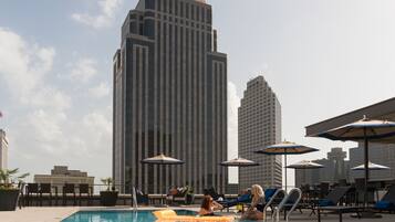 Una piscina al aire libre, sillones reclinables de piscina