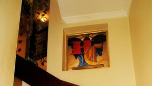 A wooden staircase with a handrail, leading to a landing with a framed artwork.