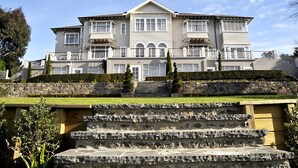 A large, two-story building with a symmetrical facade, multiple windows, and a stone staircase leading to the entrance. - Hackthorne Gardens Luxury Accommodation (Christchurch)