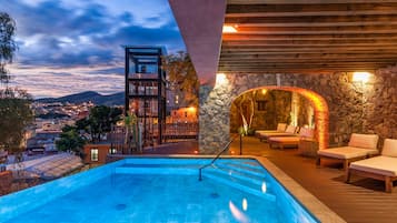 Una piscina al aire libre, sillones reclinables de piscina