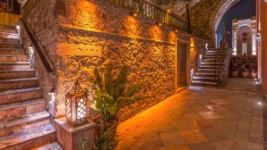 A stone staircase with a lantern and potted plant, leading to a door with a stone wall. - Casa del Rector Hotel Boutique - Adults Only (Guanajuato)