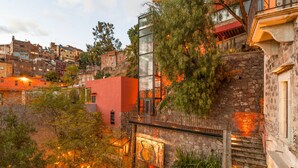 A hillside building with a glass elevator, stone steps, and a red structure. - Casa del Rector Hotel Boutique - Adults Only (Guanajuato)