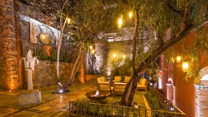 An indoor courtyard with stone walls, a fire pit, and seating areas. - Casa del Rector Hotel Boutique - Adults Only (Guanajuato)