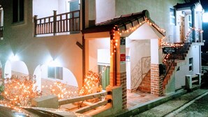 A building with a balcony, a staircase, and string lights. - dodo27 Guest House (Yeosu)