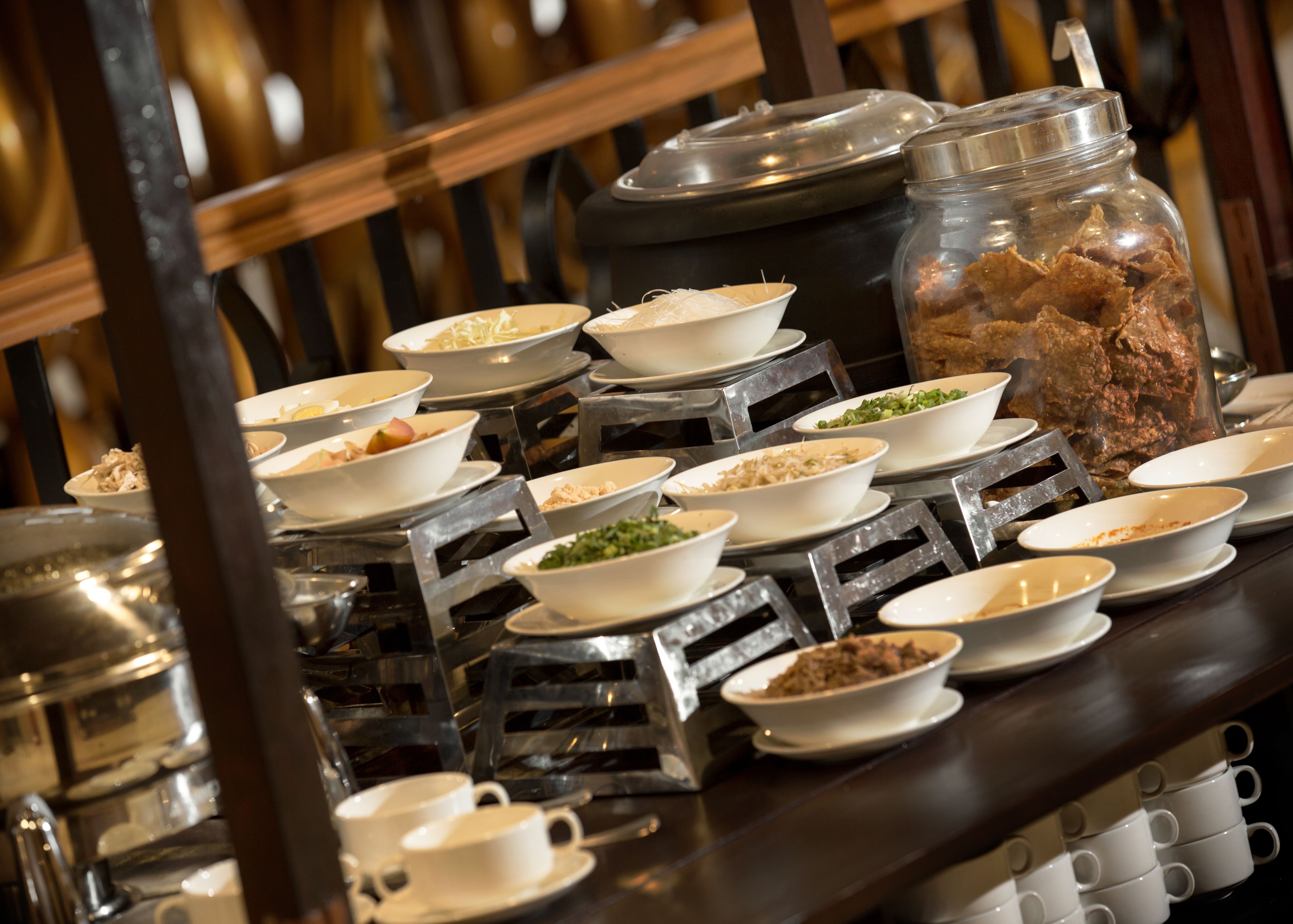 A buffet setup with multiple bowls of food on tiered stands.