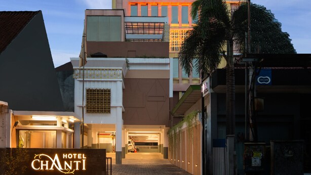 Un hotel con fachada moderna, varios pisos y una entrada destacada.