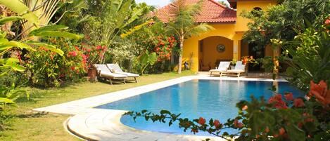 Een buitenzwembad en ligstoelen