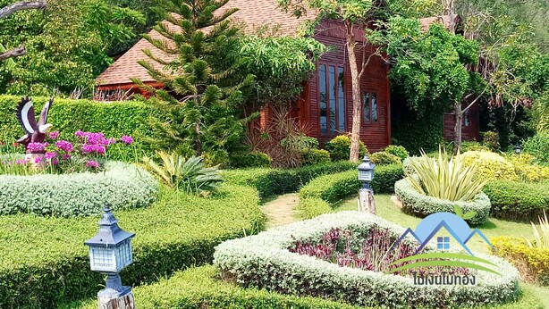 A traditional house surrounded by lush greenery and well-maintained gardens. - Mai Ngern Mai Thong Resort (Muak Lek)