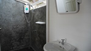 A bathroom with a shower, a sink, and a mirror. - The Pier Koh Phangan (Ko Pha-ngan)