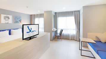 Una habitación de hotel con una cama, un escritorio, una silla y un televisor sobre el escritorio.