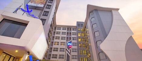 Stylish hotel building with a curved facade and prominent sign.