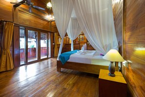 A wooden room with a bed, a nightstand, and a window with curtains. - Dawas Villa (Tibubeneng)