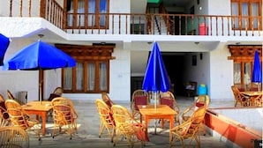 A two-story building with outdoor seating and a balcony.