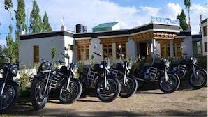 A building with a modern design, featuring a series of motorcycles parked in front.
