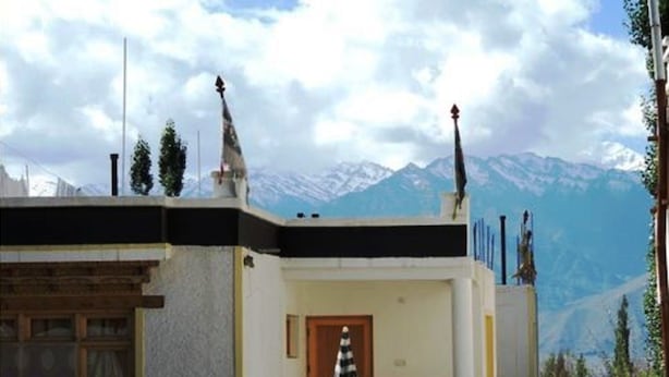 A building with a white exterior, a wooden door, and a small porch area.