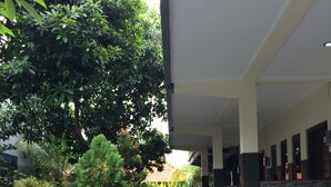 A covered outdoor area with a pool table, seating, and potted plants. - Jenny Bunker Homestay (Kuta)