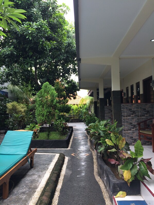 A covered outdoor area with a pool table, seating, and potted plants. - Jenny Bunker Homestay (Kuta)