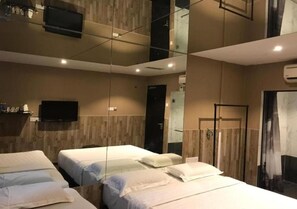 A hotel room with two beds, a flat-screen TV mounted on the wall, and a large mirror reflecting the room. - Time Hotel Seremban (Seremban)