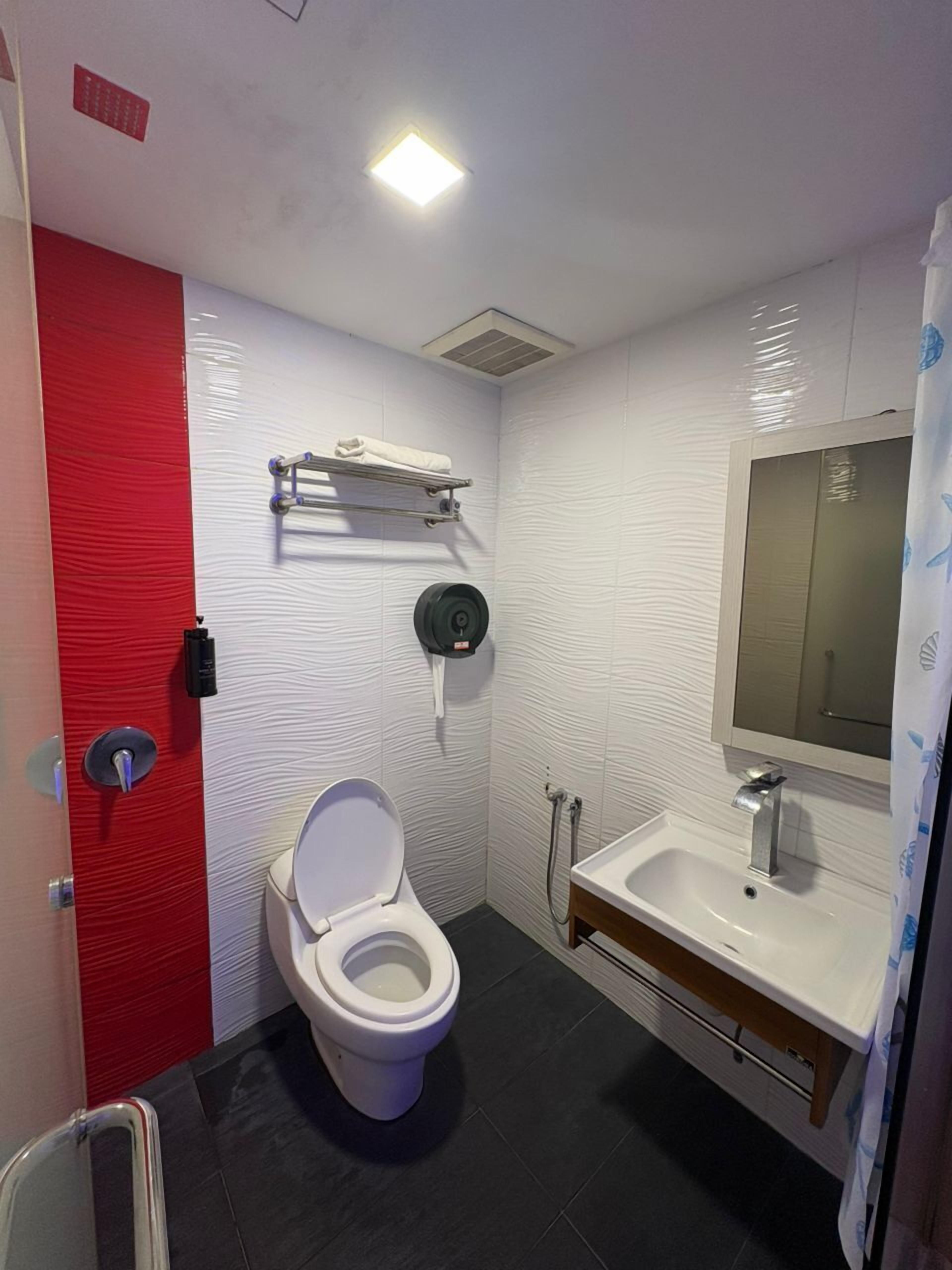 Un bagno moderno con il water bianco, un lavandino e uno specchio.