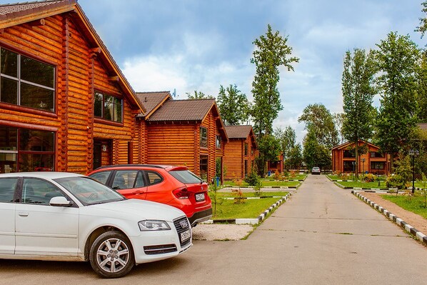 Guests can stroll along the central pathway to the gated entrance of these charming log cabin-style buildings.