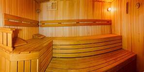 Relax in a serene sauna room with a wooden ceiling and walls, featuring comfortable benches and a clock.